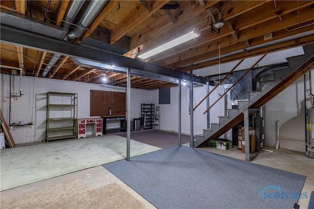 unfinished below grade area featuring water heater and stairway