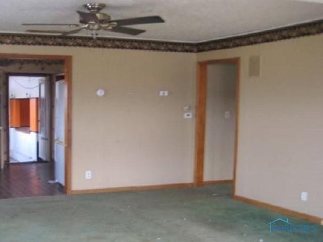 unfurnished room featuring baseboards and a ceiling fan