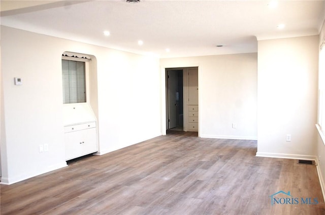 spare room featuring recessed lighting, visible vents, baseboards, and wood finished floors