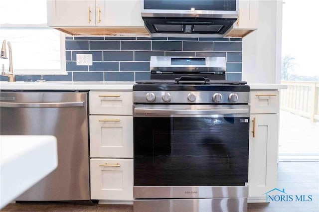 kitchen featuring tasteful backsplash, stainless steel appliances, and light countertops