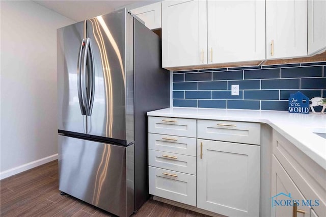 kitchen featuring freestanding refrigerator, white cabinetry, dark wood finished floors, and backsplash