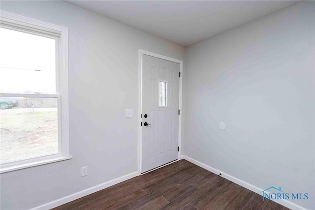 foyer entrance featuring dark wood finished floors and baseboards