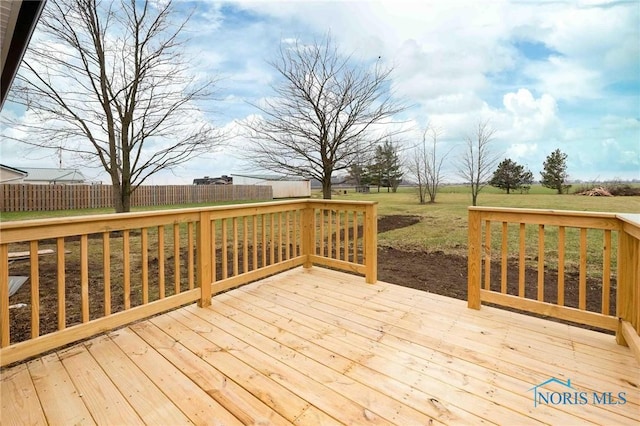 wooden terrace featuring fence, an outdoor structure, and a lawn