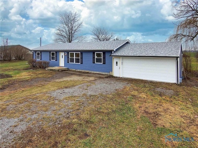 ranch-style home with driveway, a garage, a front lawn, and roof with shingles