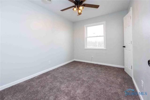 carpeted empty room featuring ceiling fan and baseboards