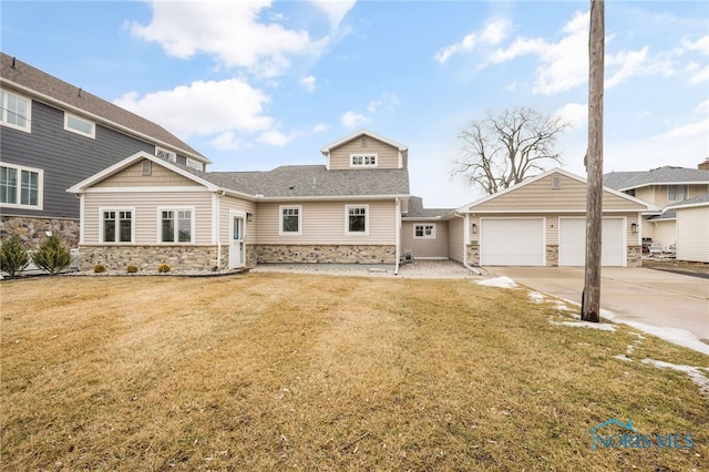 view of front of house with stone siding, a front lawn, an attached garage, and driveway