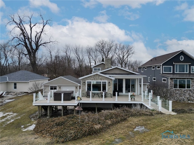 rear view of house with a deck and a lawn