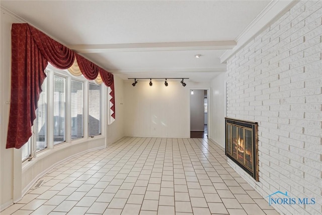 unfurnished living room featuring track lighting, light tile patterned flooring, a fireplace, and beamed ceiling