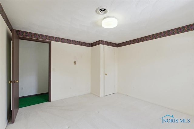 unfurnished room with visible vents and carpet flooring