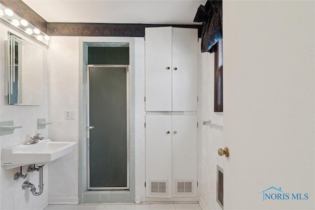 bathroom featuring a shower stall, visible vents, and a sink