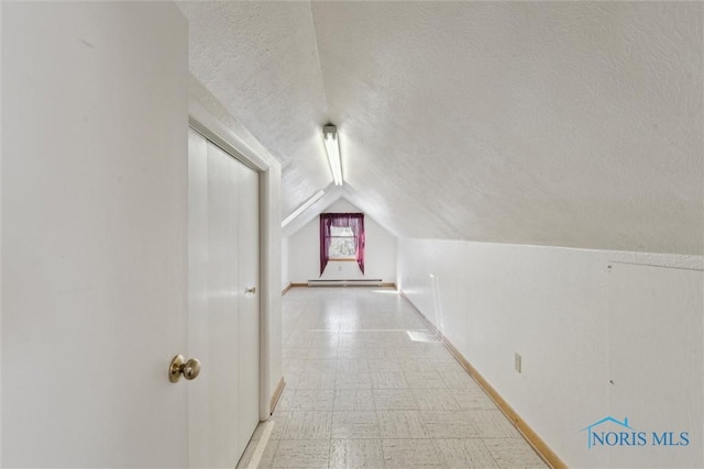 additional living space featuring lofted ceiling, a textured ceiling, and light floors