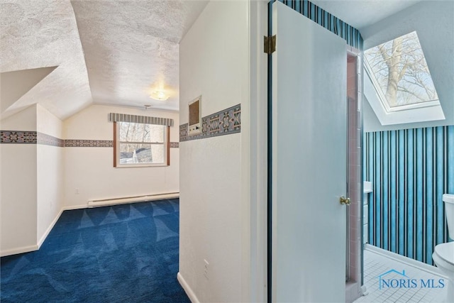 corridor with a textured ceiling, lofted ceiling, a baseboard heating unit, carpet flooring, and baseboards