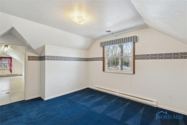 additional living space with a baseboard heating unit, lofted ceiling, dark carpet, and a textured ceiling