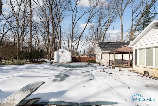 view of swimming pool featuring an outbuilding, a gazebo, a storage shed, a patio area, and fence