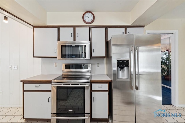 kitchen featuring white cabinetry, stainless steel appliances, light countertops, and light tile patterned flooring