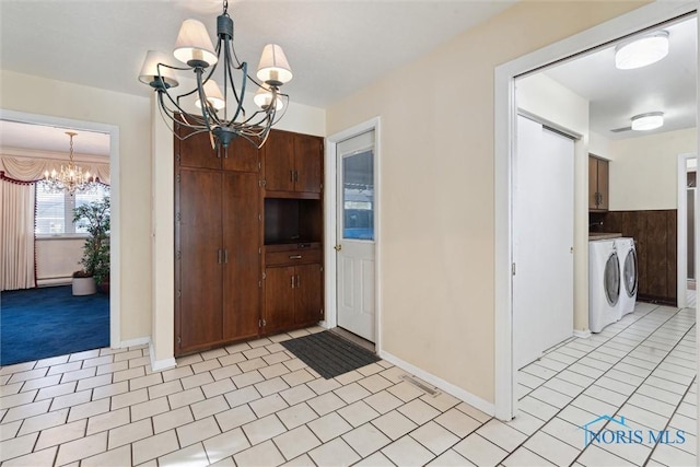 interior space featuring a chandelier, light tile patterned floors, and separate washer and dryer