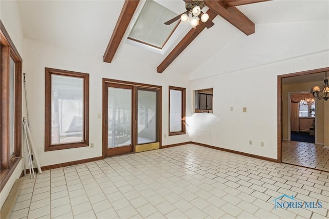 empty room featuring lofted ceiling with beams, light tile patterned floors, ceiling fan with notable chandelier, and baseboards