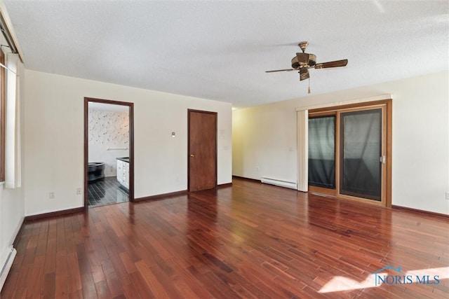 empty room with baseboards, ceiling fan, wood finished floors, baseboard heating, and a textured ceiling