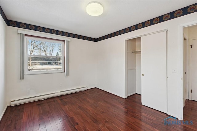 unfurnished bedroom featuring hardwood / wood-style floors, a closet, and a baseboard radiator