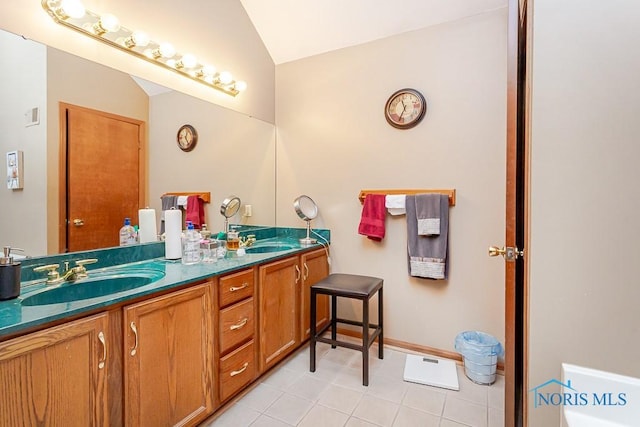 full bathroom with vaulted ceiling, a sink, and double vanity