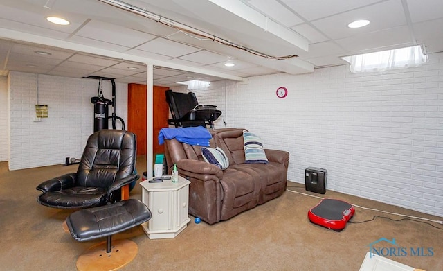 interior space with a paneled ceiling, brick wall, and recessed lighting