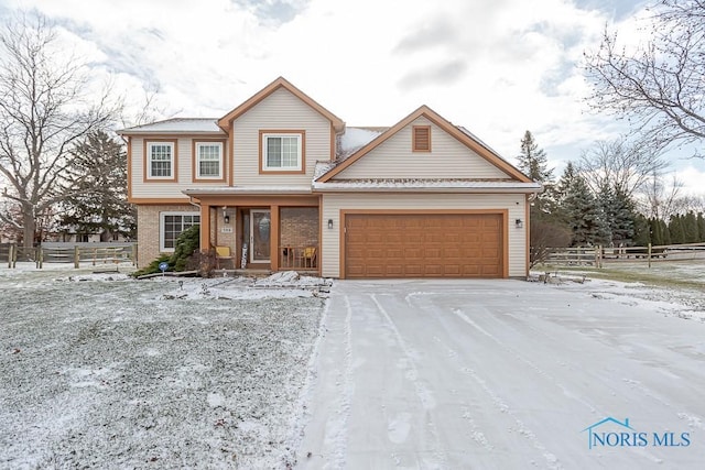 view of front of home featuring brick siding, fence, and an attached garage