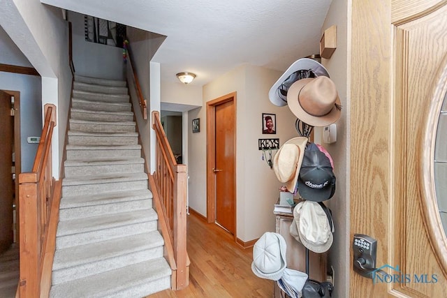 stairs with baseboards and wood finished floors