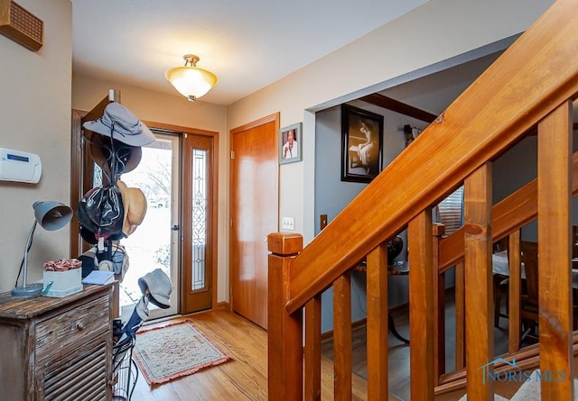 foyer entrance featuring stairway and wood finished floors