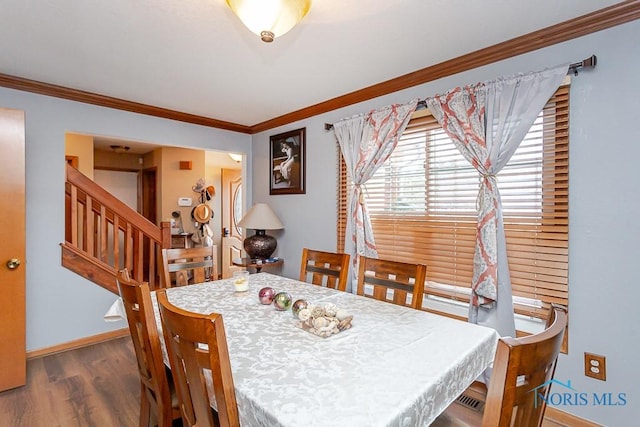 dining space featuring ornamental molding, stairway, wood finished floors, and baseboards