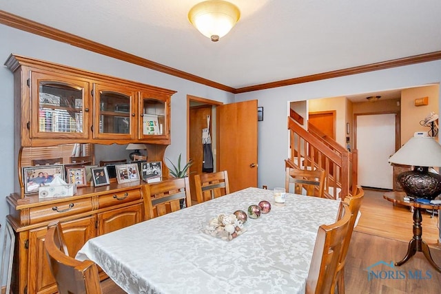 dining room featuring stairs, ornamental molding, and wood finished floors