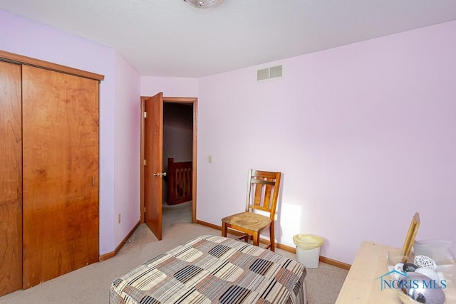 bedroom with light carpet, baseboards, visible vents, and a closet