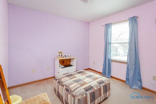 bedroom featuring light carpet and baseboards