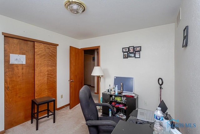 carpeted home office featuring baseboards