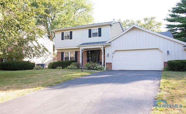 view of front of property with a garage, brick siding, driveway, and a front lawn