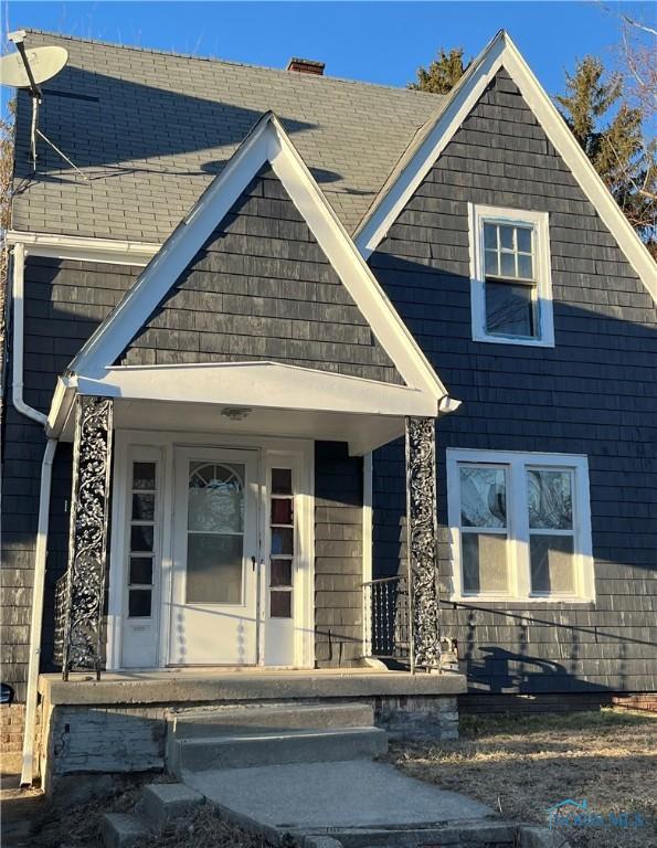 view of front facade featuring covered porch and roof with shingles