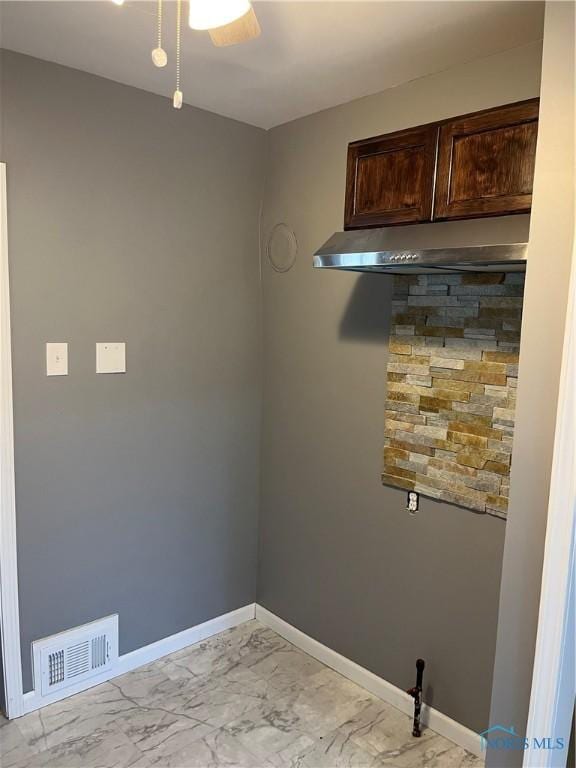 empty room with baseboards, marble finish floor, ceiling fan, and visible vents