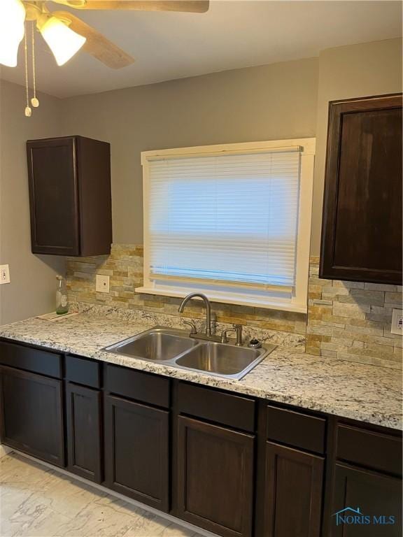 kitchen with backsplash, light countertops, a sink, and dark brown cabinets