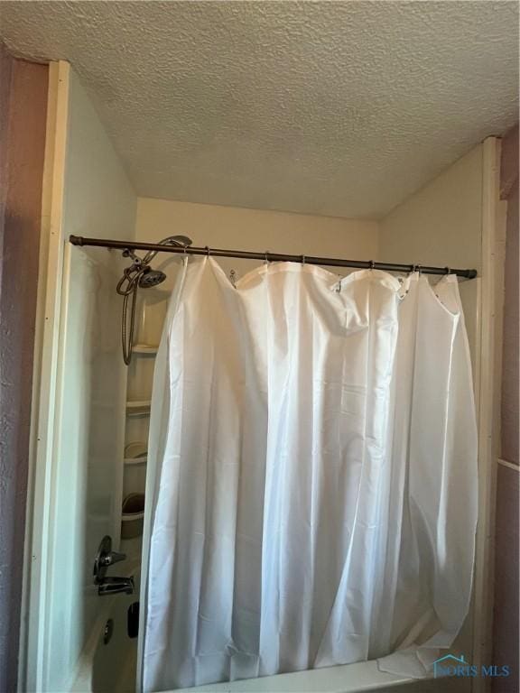 full bath featuring shower / bath combination with curtain and a textured ceiling