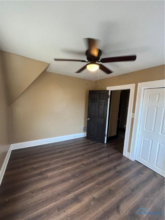 unfurnished bedroom with baseboards, dark wood-style flooring, and ceiling fan