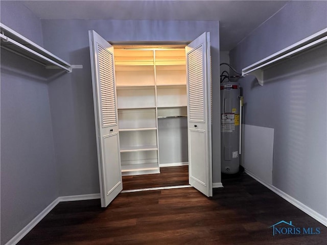 walk in closet featuring water heater and wood finished floors