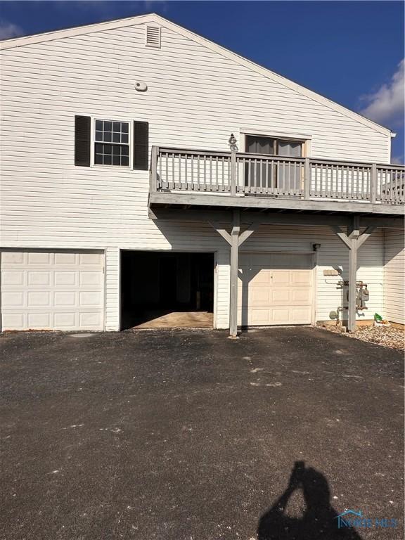 back of property with aphalt driveway and an attached garage