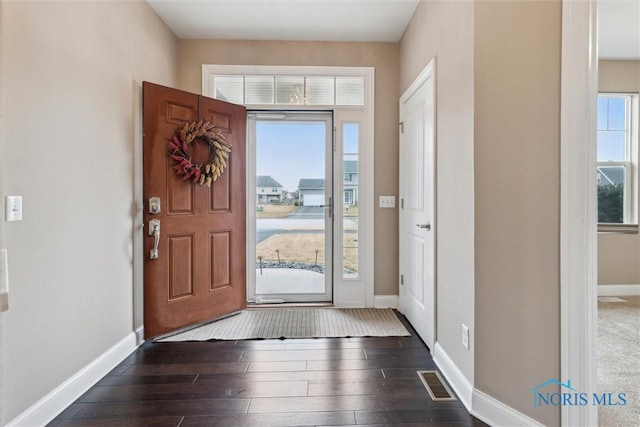 entrance foyer with baseboards, dark wood-style flooring, and a wealth of natural light