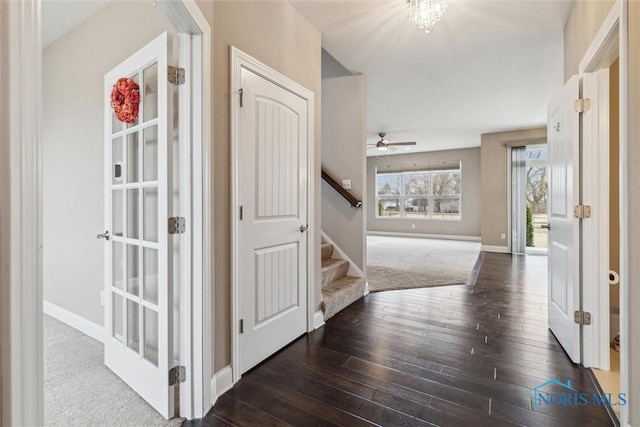 corridor featuring stairway, baseboards, and hardwood / wood-style flooring