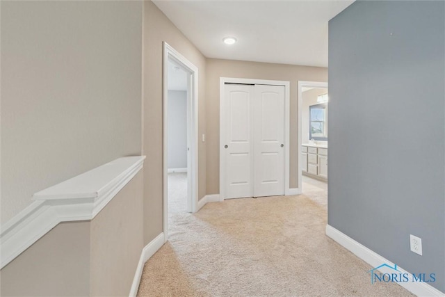 hall with light carpet and baseboards