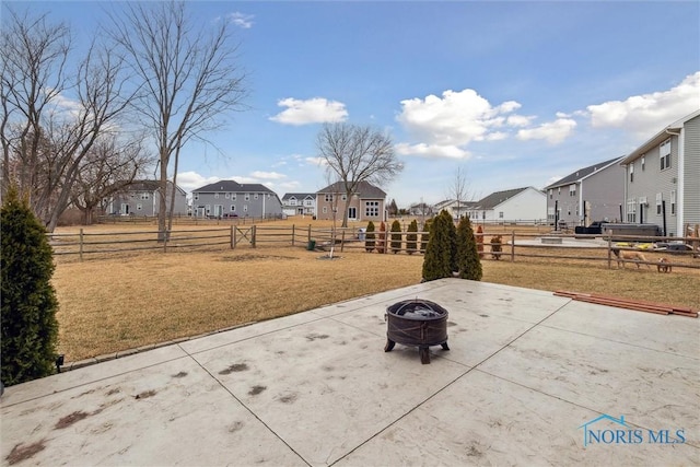 view of patio with fence, a fire pit, and a residential view