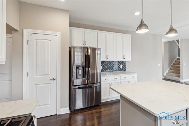 kitchen with pendant lighting, dark wood finished floors, stainless steel refrigerator with ice dispenser, decorative backsplash, and white cabinetry