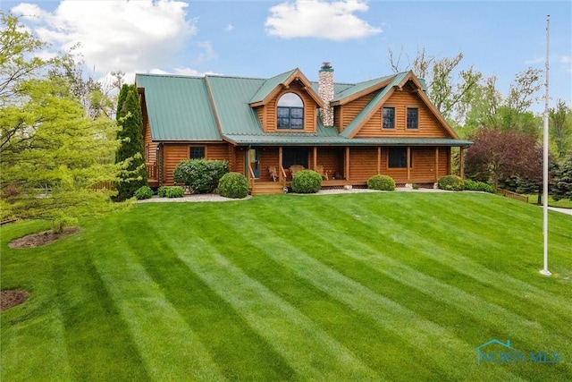 view of front of home with a chimney, a porch, and a front yard