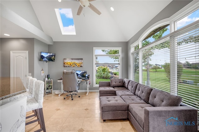 living room with light tile patterned floors, a skylight, baseboards, a ceiling fan, and high vaulted ceiling