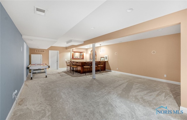 interior space featuring carpet floors, baseboards, visible vents, and a dry bar