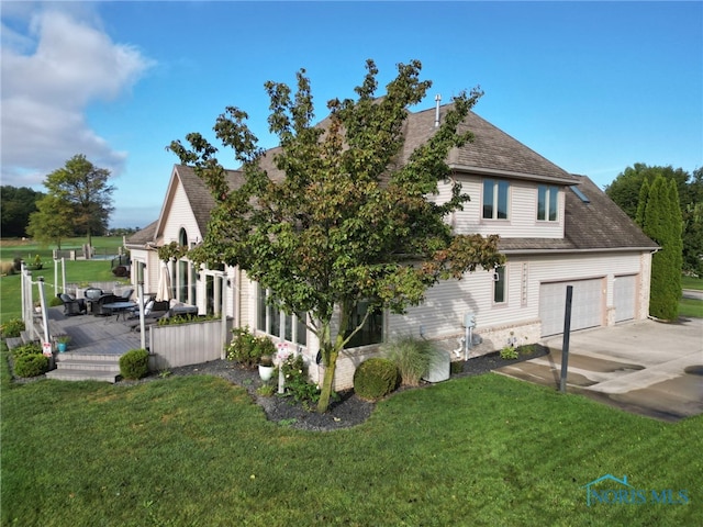 view of side of home with a yard, roof with shingles, an attached garage, and driveway